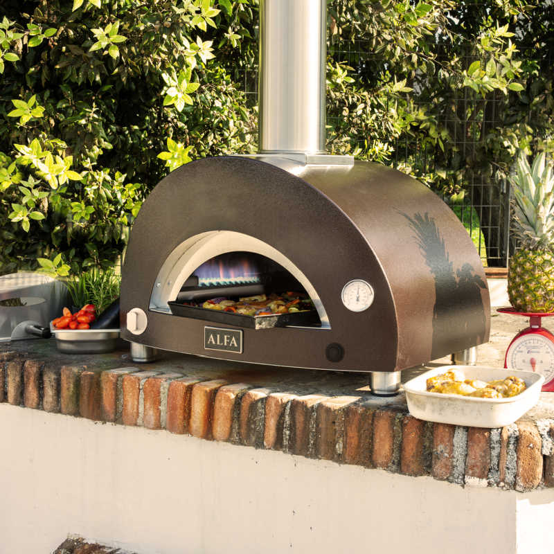 Compact pizza oven on bench cooking pizza.