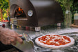 ALFA FORNI Nano Wood Pizza Oven on table with pizza being prepped in front.